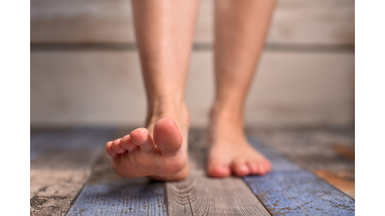Barefoot woman with clean feet stepping on floor