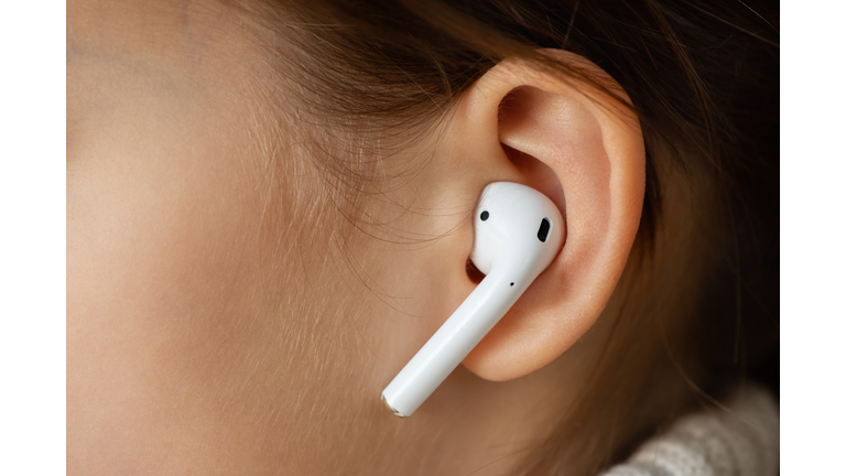 Wireless earphone in the girl's ear.