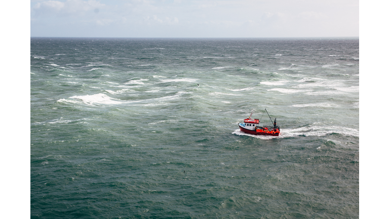 Aerial view of small fishing boat in open ocean