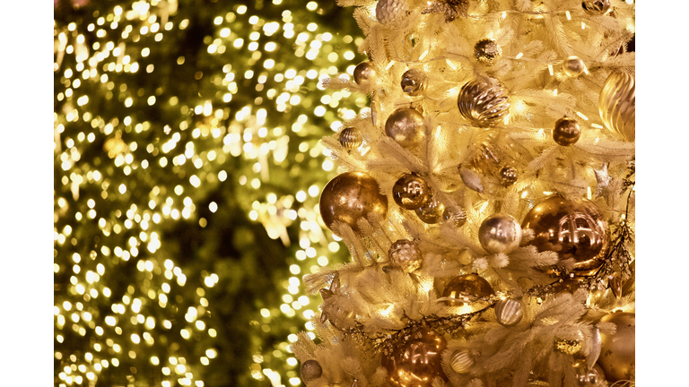 White snowy Christmas tree decorated with beautiful golden Christmas decorations