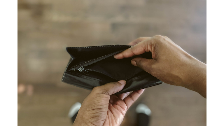 Woman Looks Into Empty Wallet