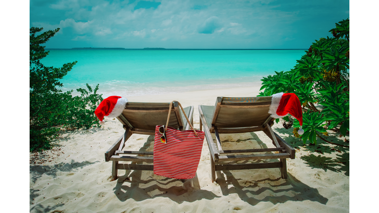 Christmas on beach -chair lounges with Santa hats at sea