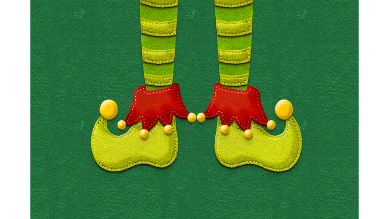 elf feet made of felt in green background with copyspace