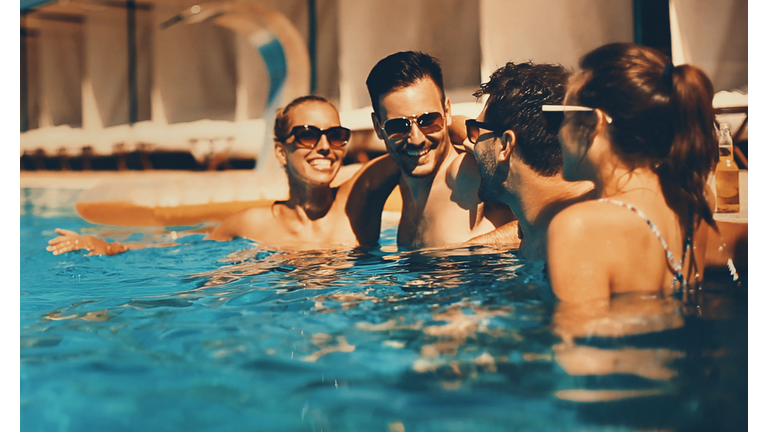 People enjoying drinks by the swimming pool.