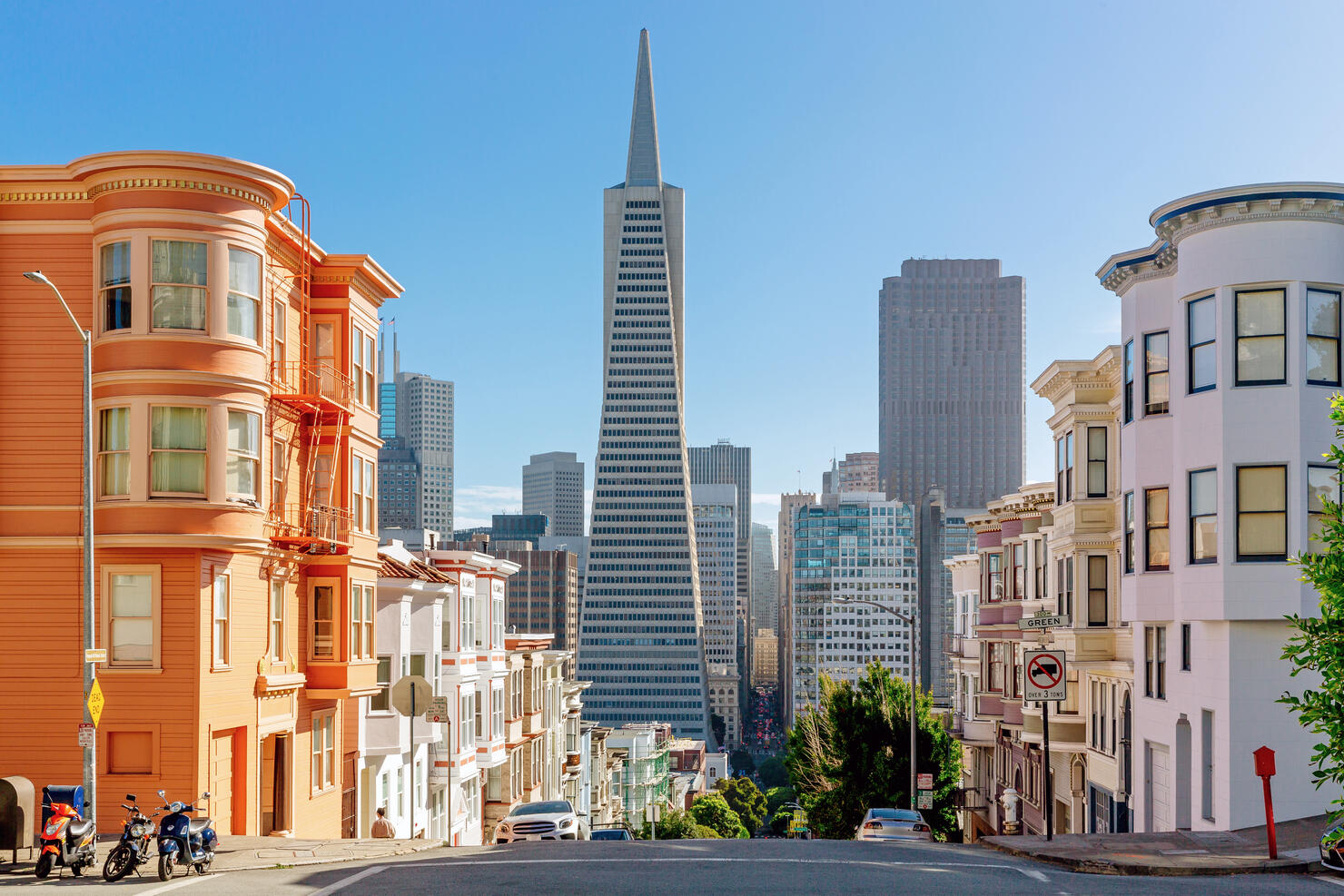 Street with residential building and skyscrapers of San Francisco Financial District in the background, California, USA