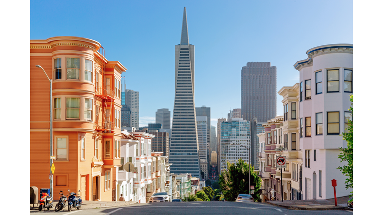 Street with residential building and skyscrapers of San Francisco Financial District in the background, California, USA
