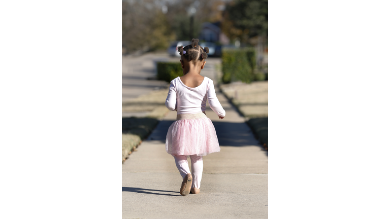 Toddler walking down sidewalk