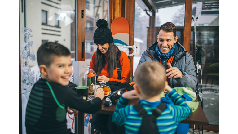 Family drinking hot tea after skiing