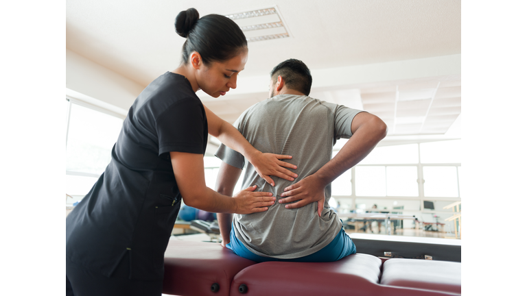 Female massage therapist massaging patient's back
