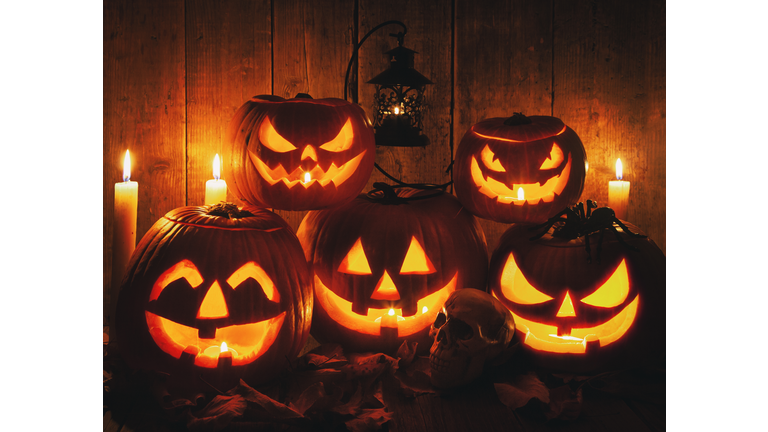 Halloween Jack-o-Lantern Pumpkins on rustic wooden background