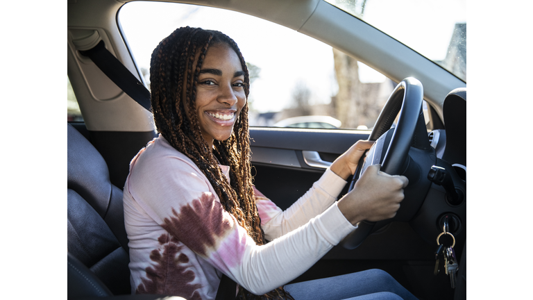 Portrait of teenage girl in her first car