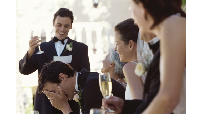 Best man making a speech on the head table at a wedding reception