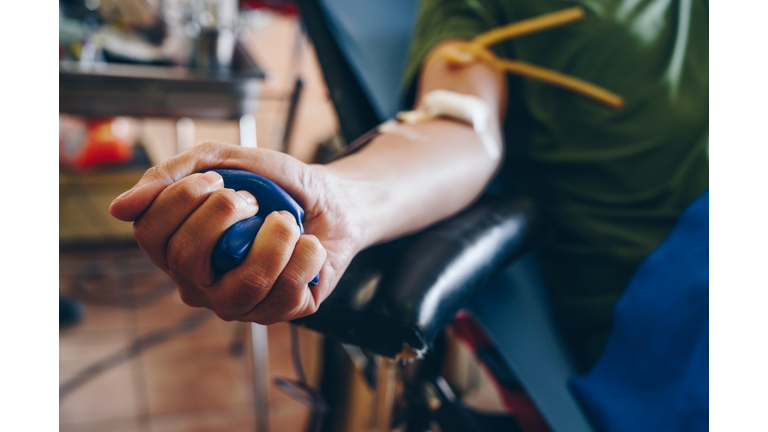 Cropped shot of someone squeeze a squish ball while donating blood.