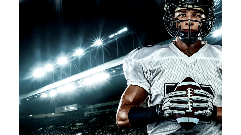 American football player, in helmet on stadium. Sport action concept.