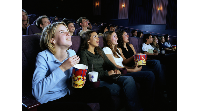 Multi-ethnic teen girls (16-18)  watching movie in theater