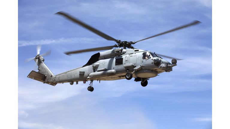 Looking up at a Seahawk helicopter flying in blue sky