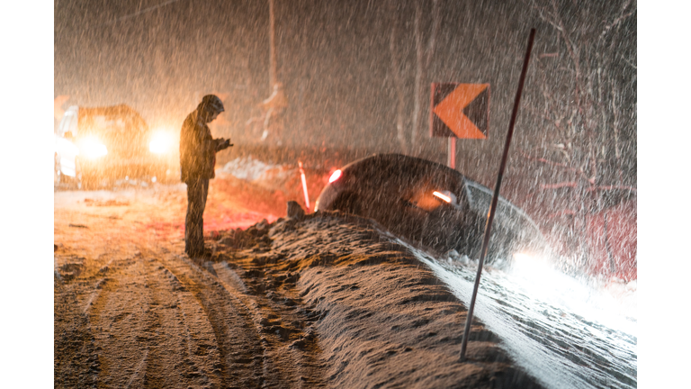 Man calling for help for car accident in snow