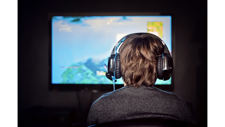 Caucasian little gamer boy wearing a headset plays video game. Video game addiction.