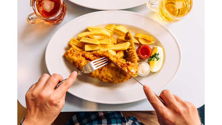 Man eating fish and chips in a pub, personal perspective directly above view