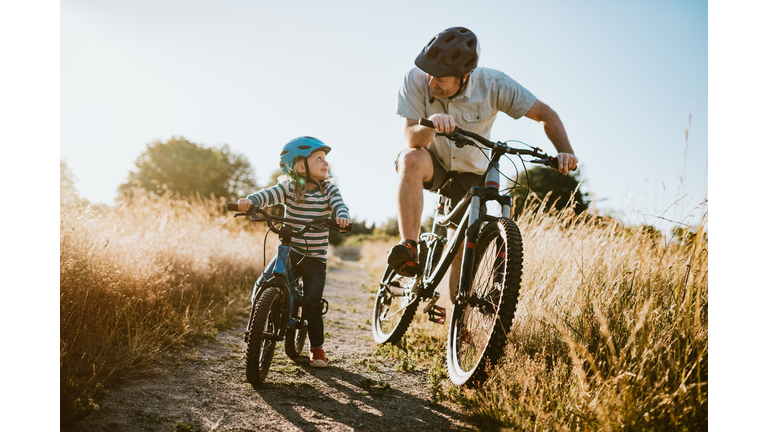 Father and Daughter Mountain Bike Riding Together on Sunny Day