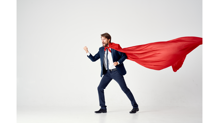 Male superhero in a suit and red coat over white background