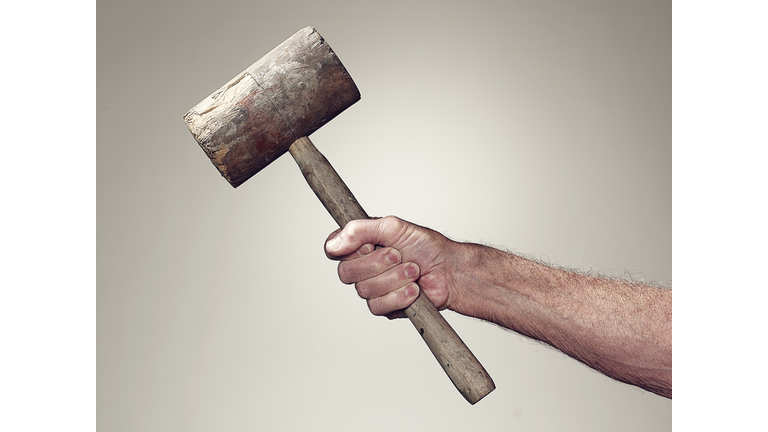 Hand holding wooden mallet