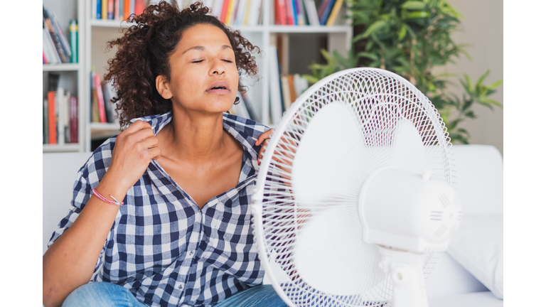 Black woman feeling hot and trying to refresh