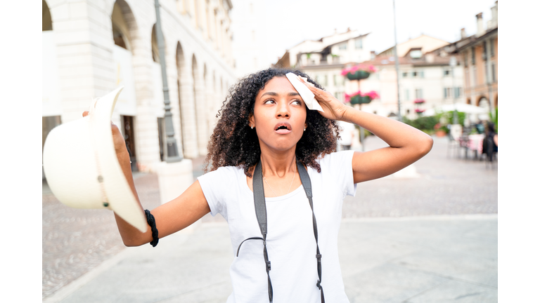 Afro woman stressed by heatwave summer in the city