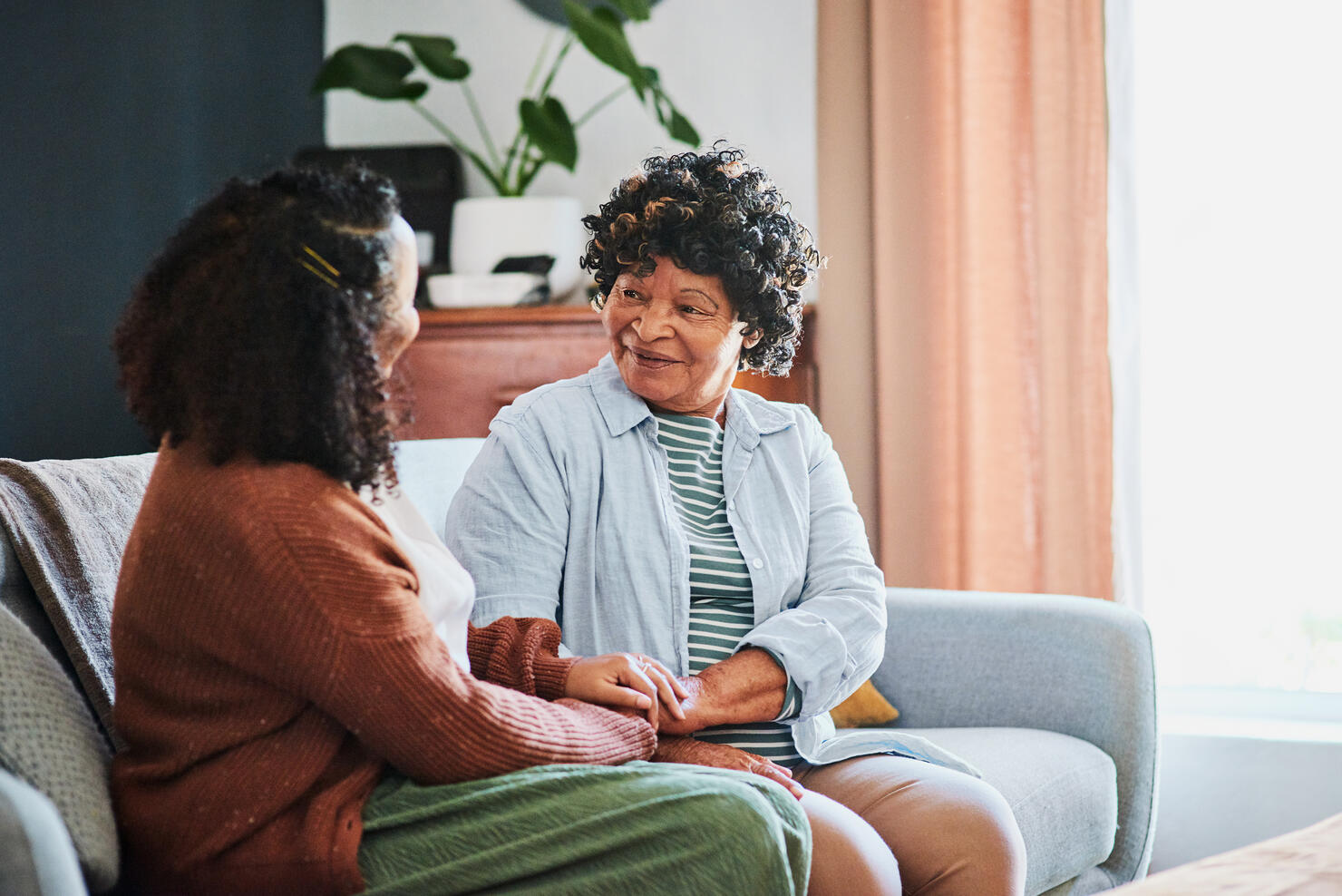 Shot of an elderly woman relaxing with her daughter on the sofa at home