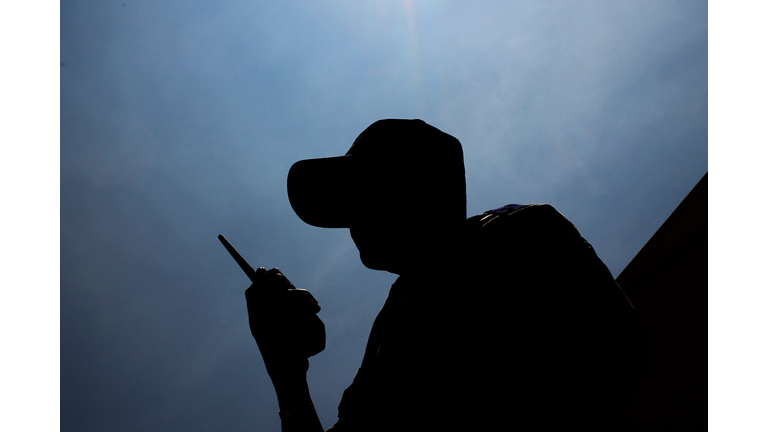 Low Angle View Of Security Guard With Walkie-Talkie Against Sky