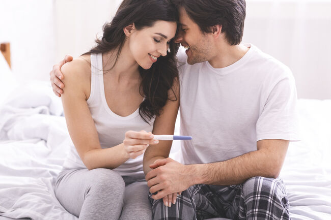 Happy couple enjoying positive result of pregnancy test