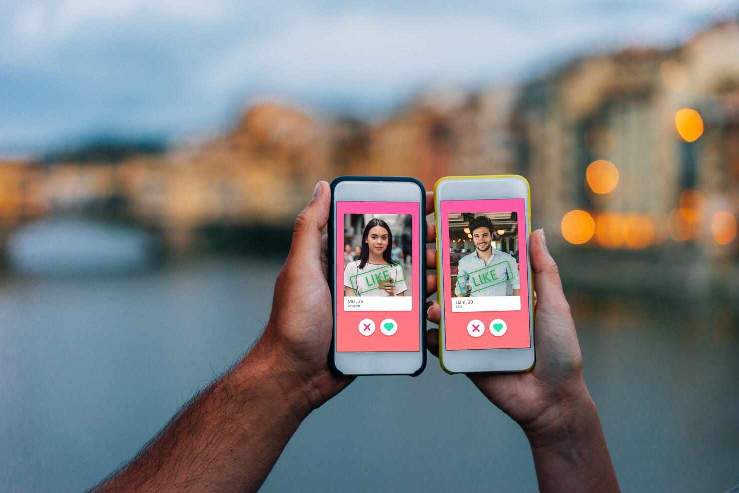 Conceptual image of two hands holding smart phones with an online dating app on the screen