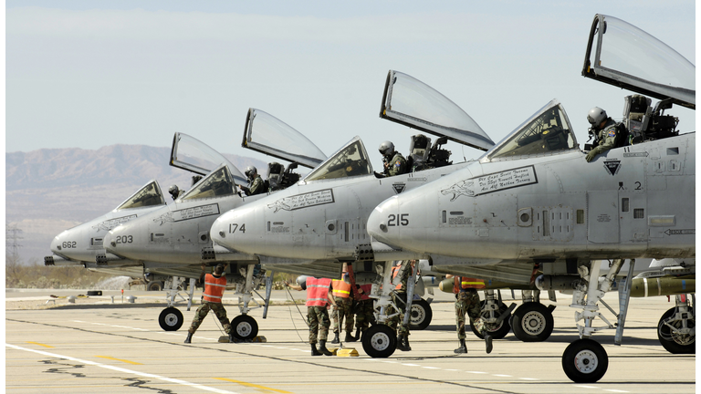 "Four A-10 Thunderbolt IIs sit on the end of the runway as maintainers perform pre-flight inspections at Davis-Monthan Air Force Base, Arizona, Thursday, March 23, 2006, as part of the 2006 Hawgsmoke competition."
