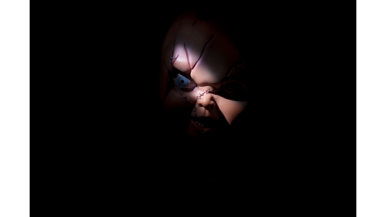 Close-Up Of Sewed Chucky Toy Against Black Background