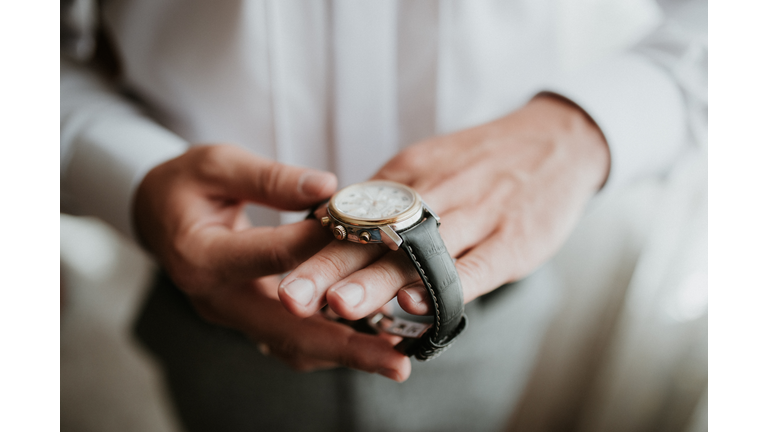 businessman checking time on his wrist watch, man putting clock on hand,groom getting ready in the morning before wedding ceremony