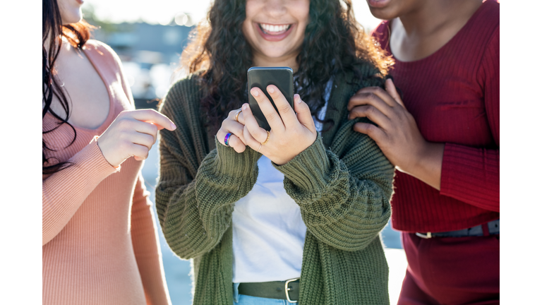 Group of female friends using a mobile phone together