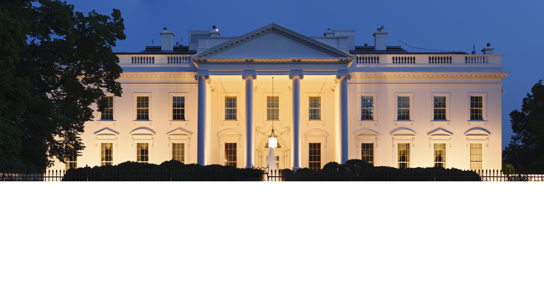 A photograph of the White House at night