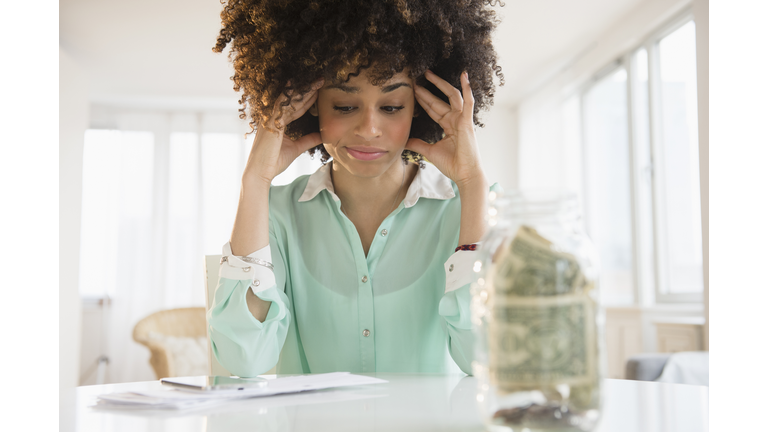 Stressed mixed race woman paying bills