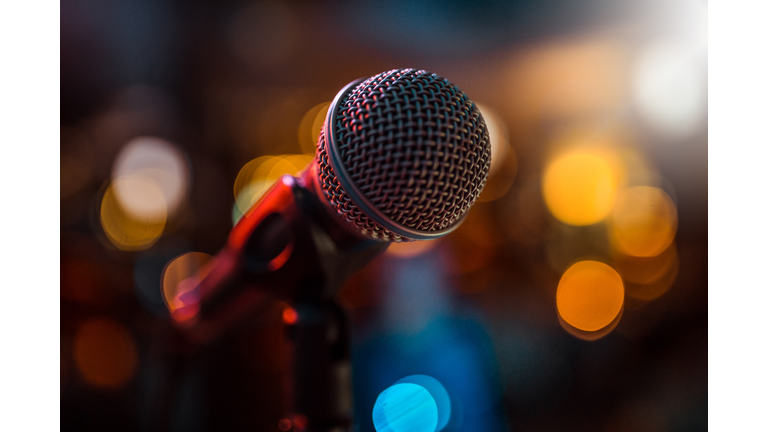 close-up stage microphone with blurry lights in the background