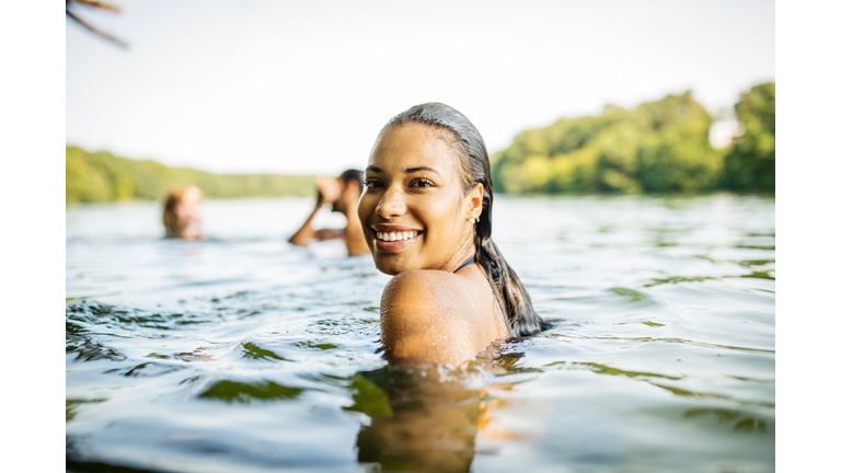 Smiling woman in a lake with friends