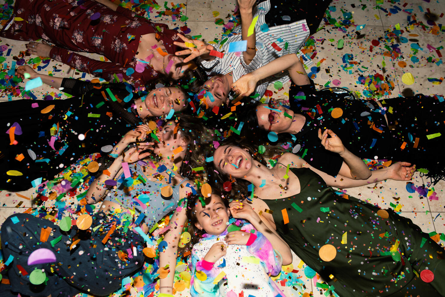 Group of friends having fun with confetti at home.