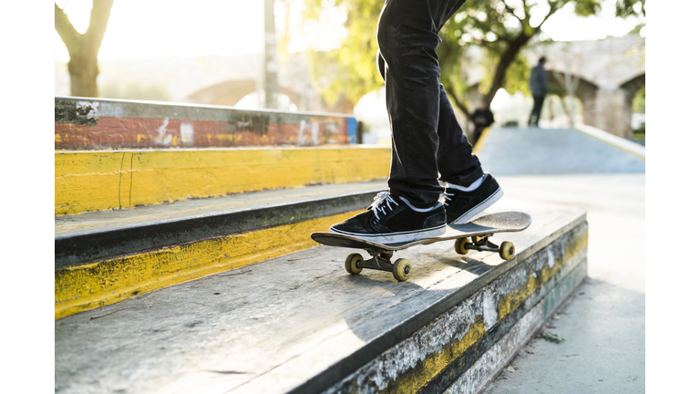 Legs of a skateboarder in a skatepark