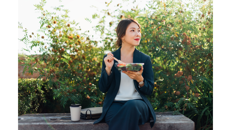 Businesswoman Having Taking A Lunch Break Outdoors