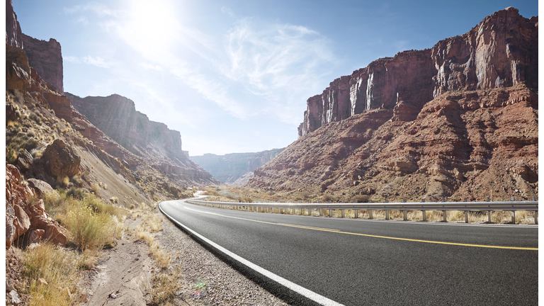 Empty curved road in sandstone cliff valley