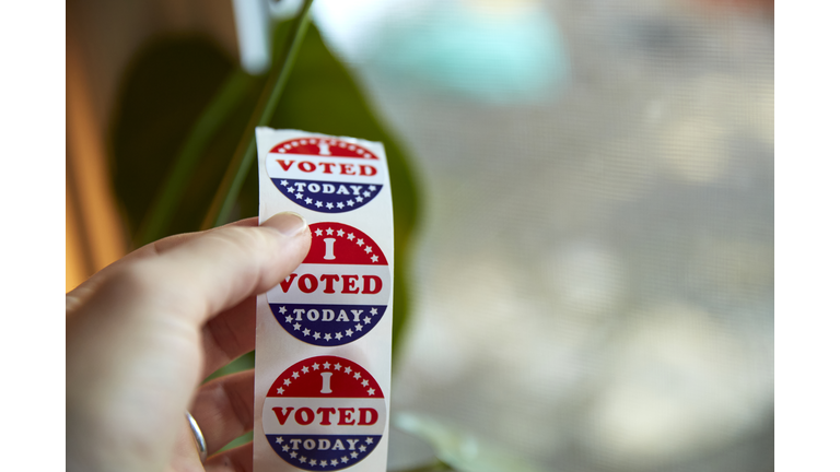 A person taking an "I Voted Today" sticker after casting their ballot.