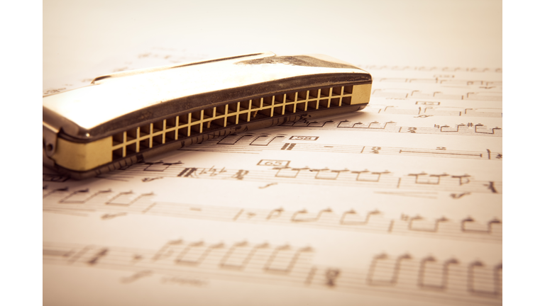 A harmonica on a sheet of music