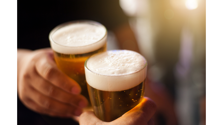 Cheers! Clink glasses. Close-up shots of hands holding beer glasses and beer bubbles.