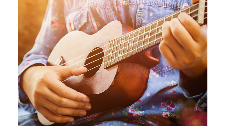 Little girl playing ukulele guitar