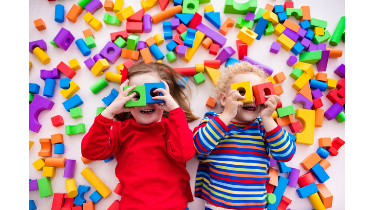 Children playing with colorful blocks building a block tower