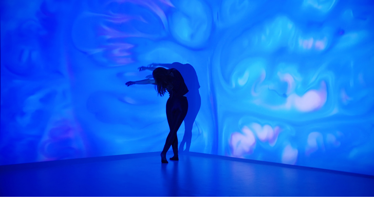 Multicolor background projection upon a female dancer